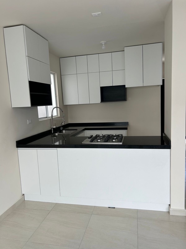 Cocina blanca en forma de U con cubierta de cuarzo negro en Fracc Platino, Apodaca
